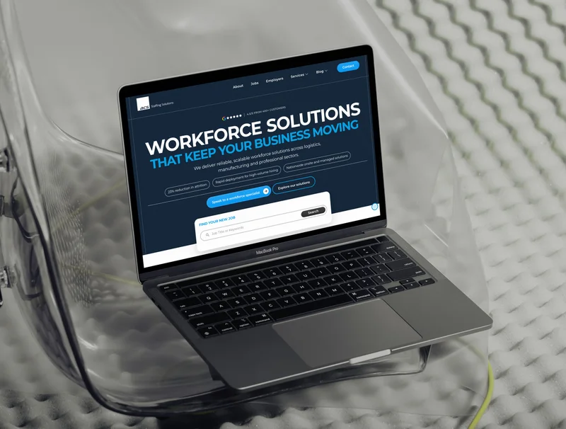 The ACS Staffing Solutions homepage on a laptop resting on a transparent chair