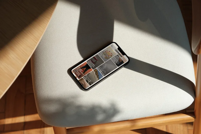The Grounded website on a phone resting on a cream chair