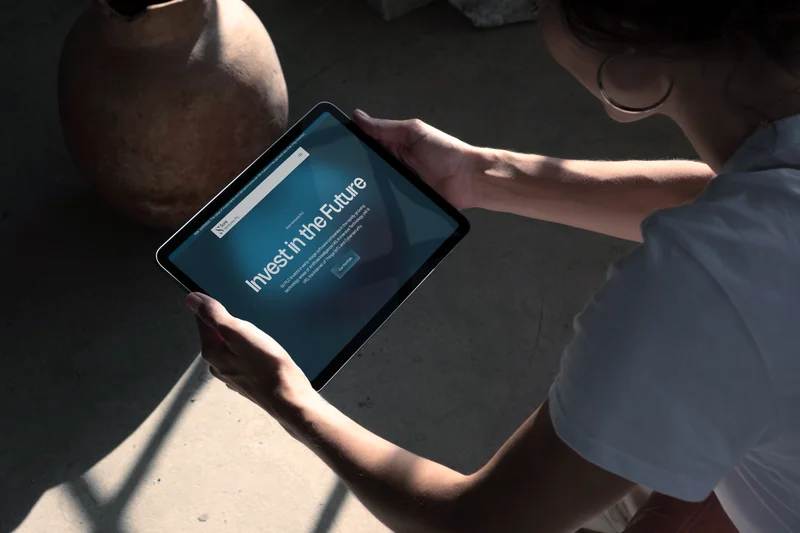 The Sure Ventures PLC homepage on a tablet, held in both hands