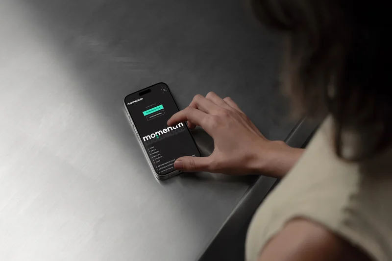 The Momentm site on a phone, on a steel table