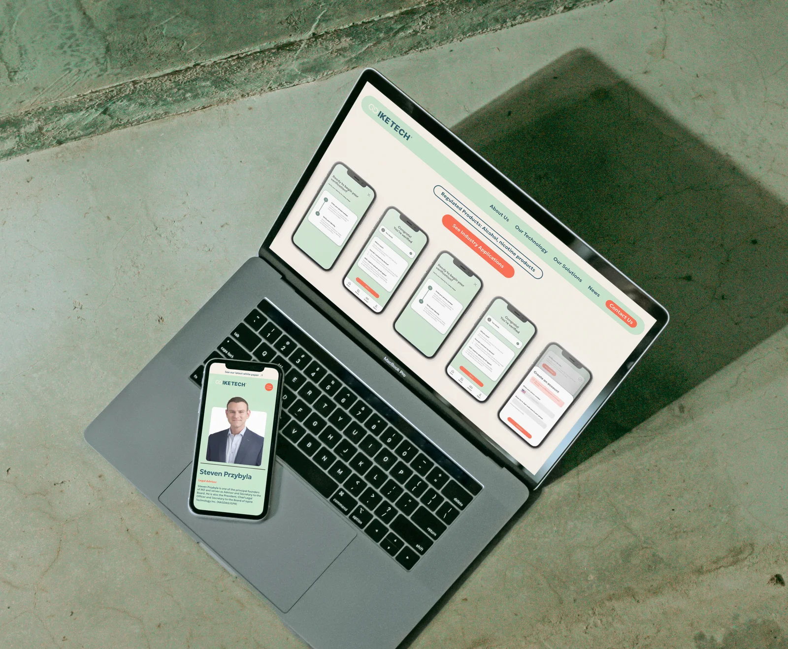 The IKE Tech technology page on a laptop, with the team page on a phone resting on the keyboard